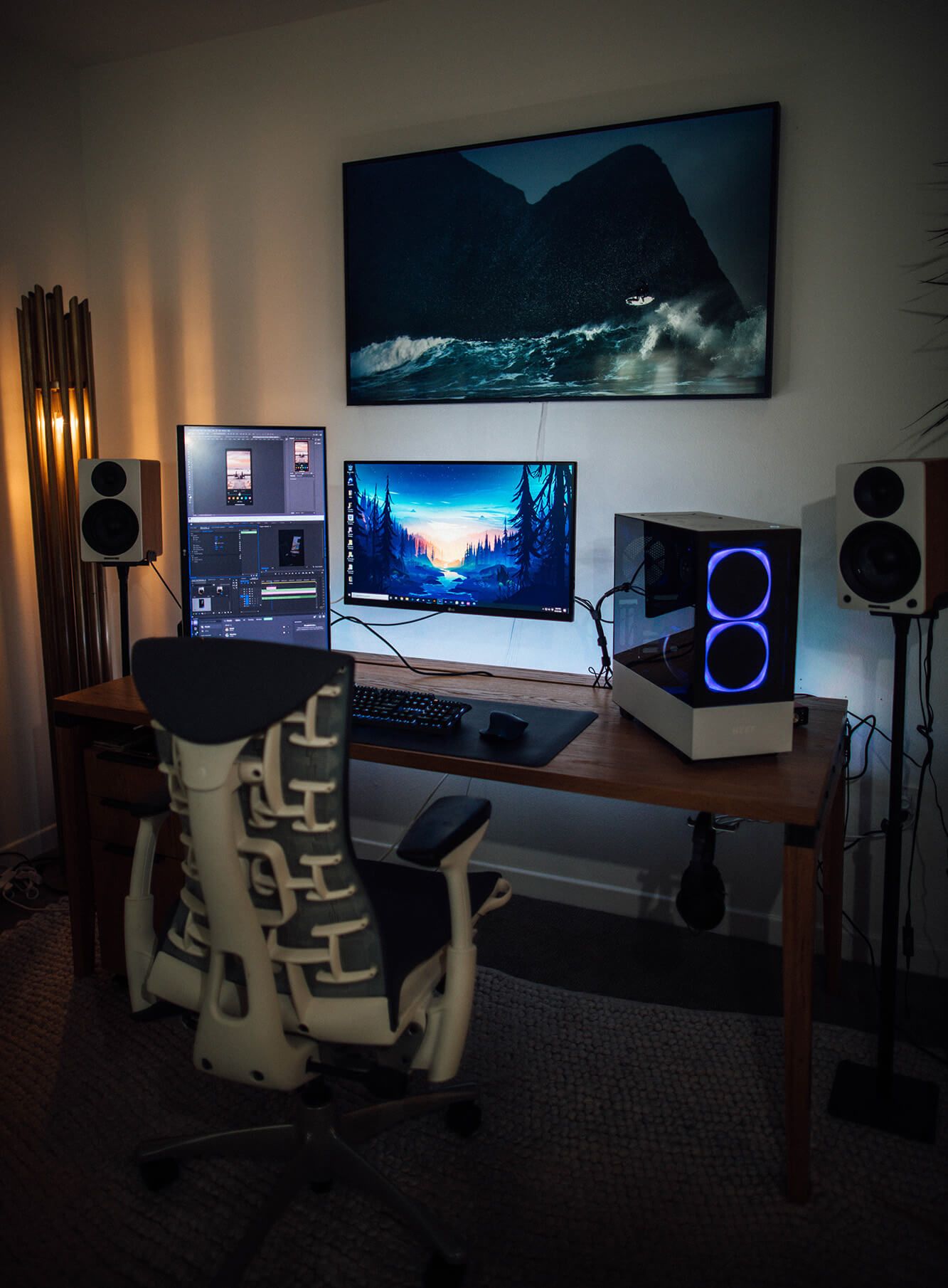 A dark and moody desk setup featuring Herman Miller Embody chair